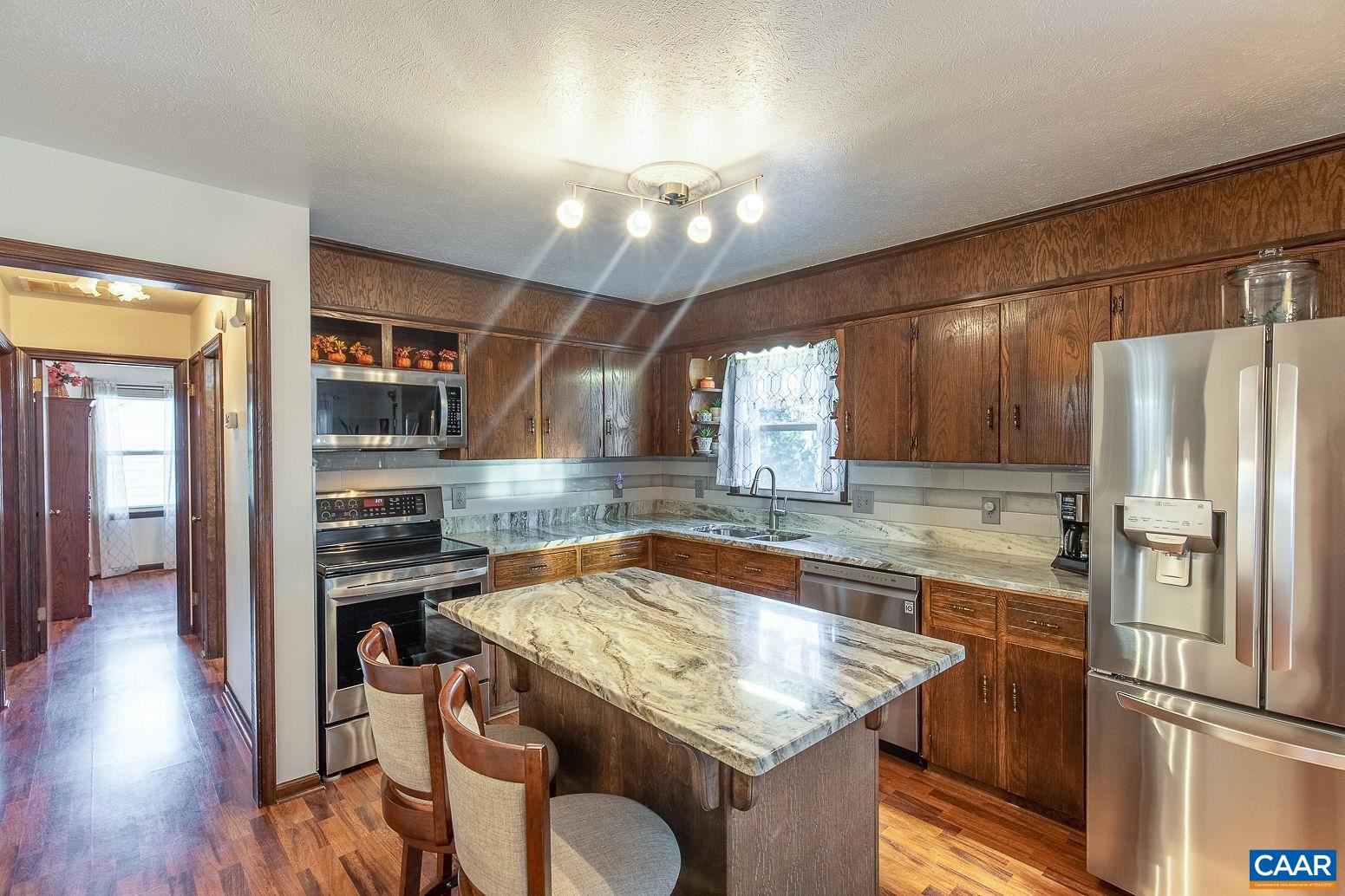 3248 Welsh Run Road Ruckersville, VA 22968 - Photo 9 of 43 a kitchen with a table chairs refrigerator and cabinets