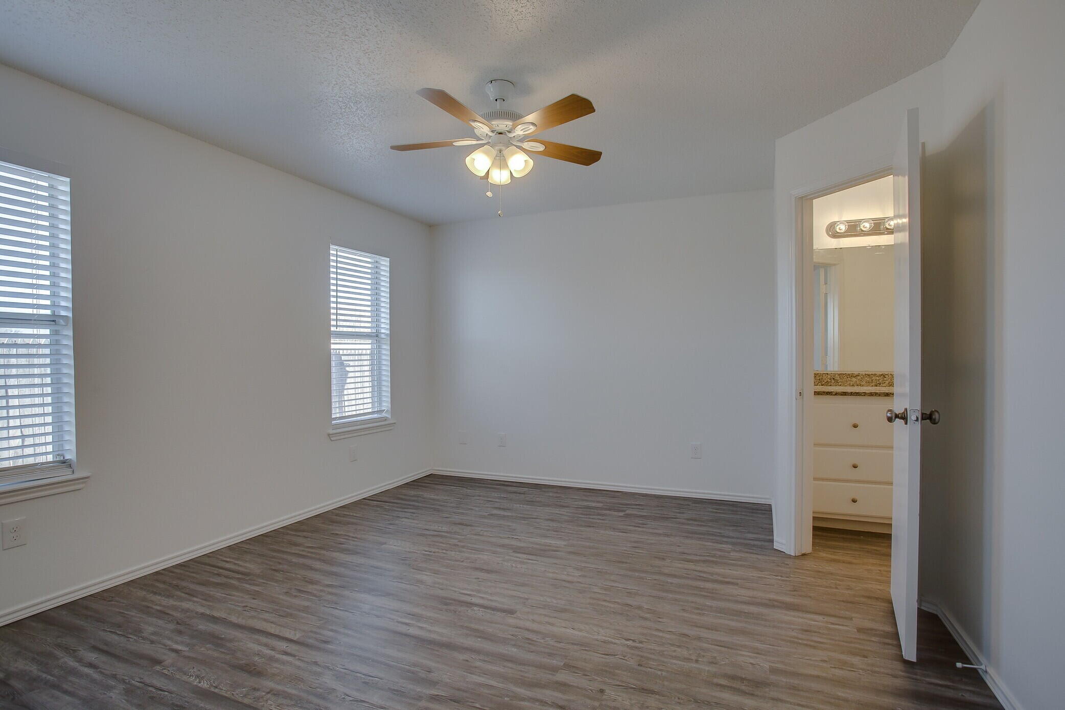 2514 108th Drive Lubbock, TX 79423 - Photo 11 of 16 an empty room with wooden floor closet and windows