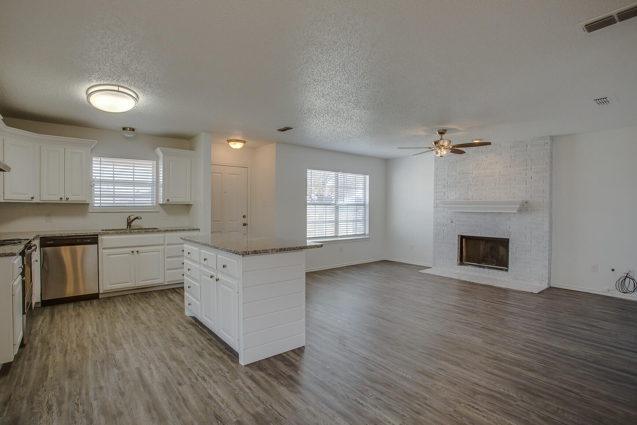 2514 108th Drive Lubbock, TX 79423 - Photo 3 of 16 a kitchen with granite countertop a stove top oven sink and cabinets