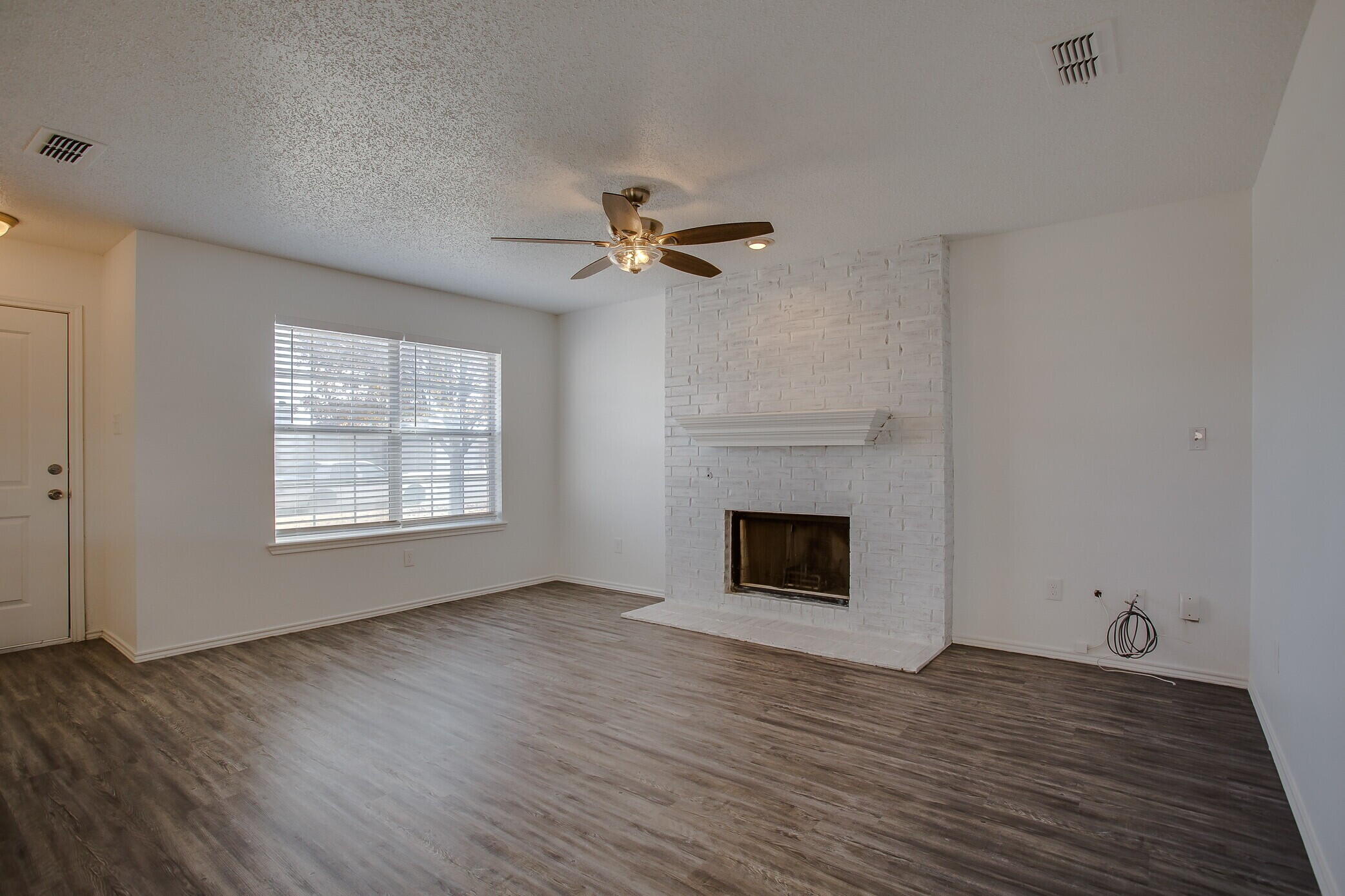 2514 108th Drive Lubbock, TX 79423 - Photo 4 of 16 a view of an empty room with a fireplace and a window