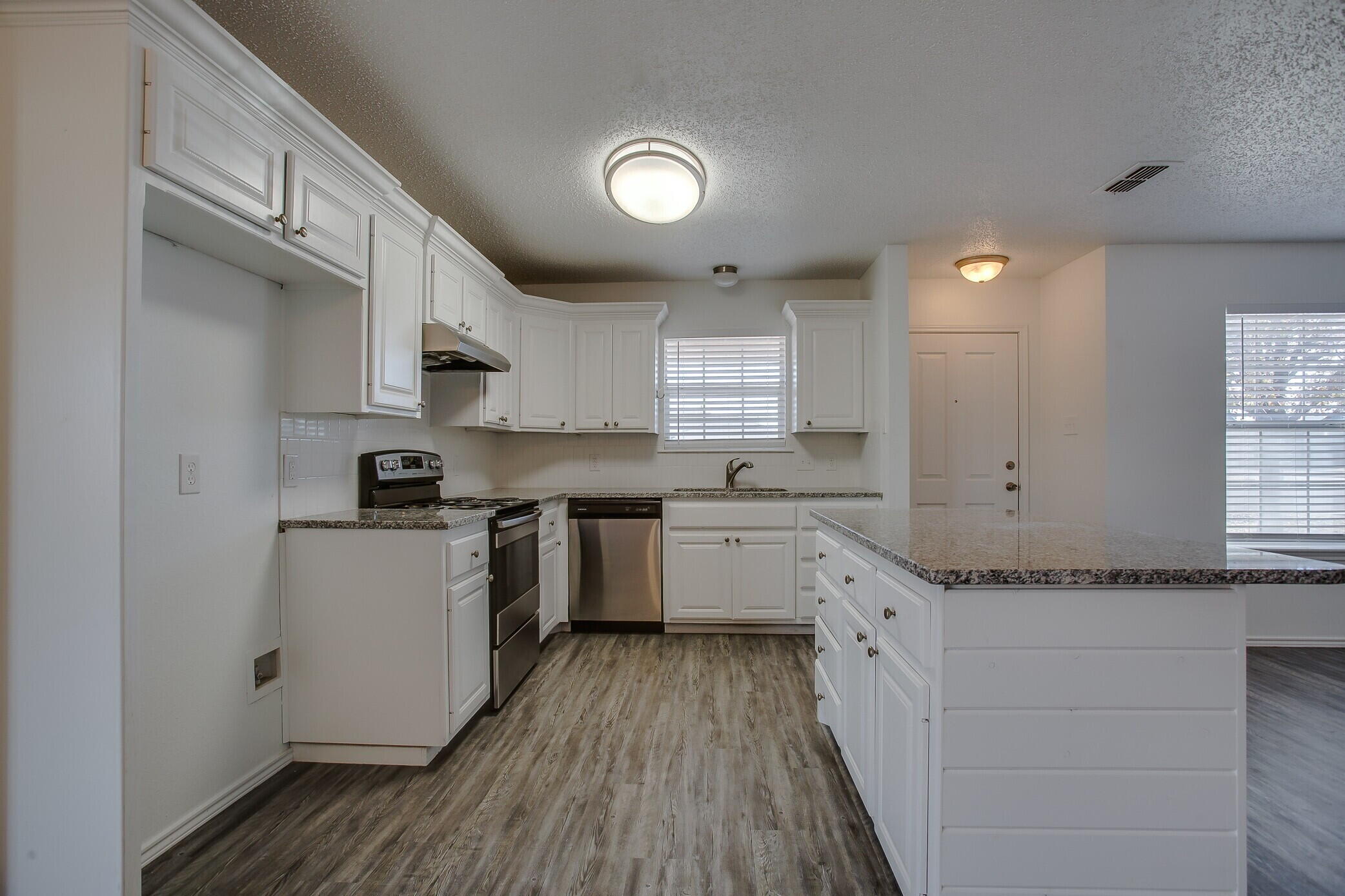 2514 108th Drive Lubbock, TX 79423 - Photo 8 of 16 a kitchen with granite countertop a sink cabinets stainless steel appliances and a window