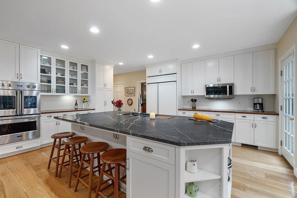 18 Wheeler Road Lincoln, MA 01773 - Photo 7 of 42 a kitchen with stainless steel appliances granite countertop a table chairs sink and cabinets