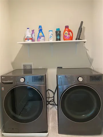 a utility room with dryer washer and racks
