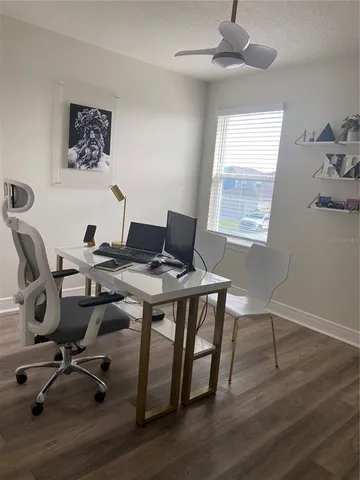 a view of a workspace with furniture and a window