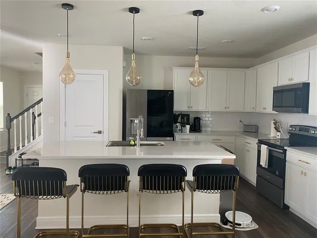a kitchen with a dining table chairs and white cabinets