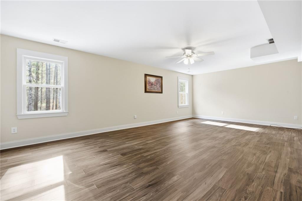 152 Jefferson Drive Dallas, GA 30132 - Photo 31 of 47 an empty room with wooden floor ceiling fan and windows