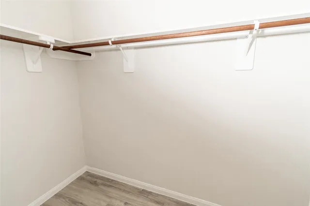 an empty room with wooden floor and closet