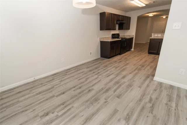 a large kitchen with a sink a microwave and cabinets