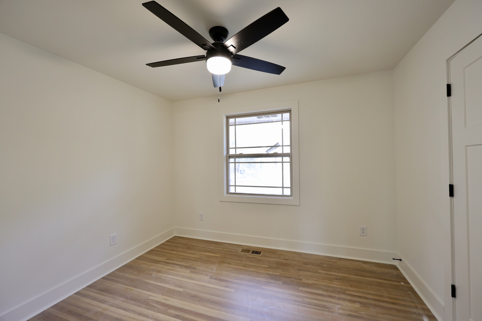 4392 Ashland City Road Clarksville, TN 37043 - Photo 17 of 19 an empty room with wooden floor ceiling fan and windows