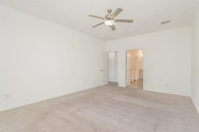 an empty room with a ceiling fan and a window
