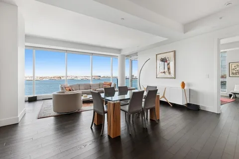 a kitchen that has a lot of white cabinets and stainless steel appliances
