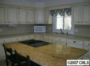 3227 Gray Moss Road Charlotte, NC 28270 - Photo 3 of 8 a kitchen with a table and cabinets