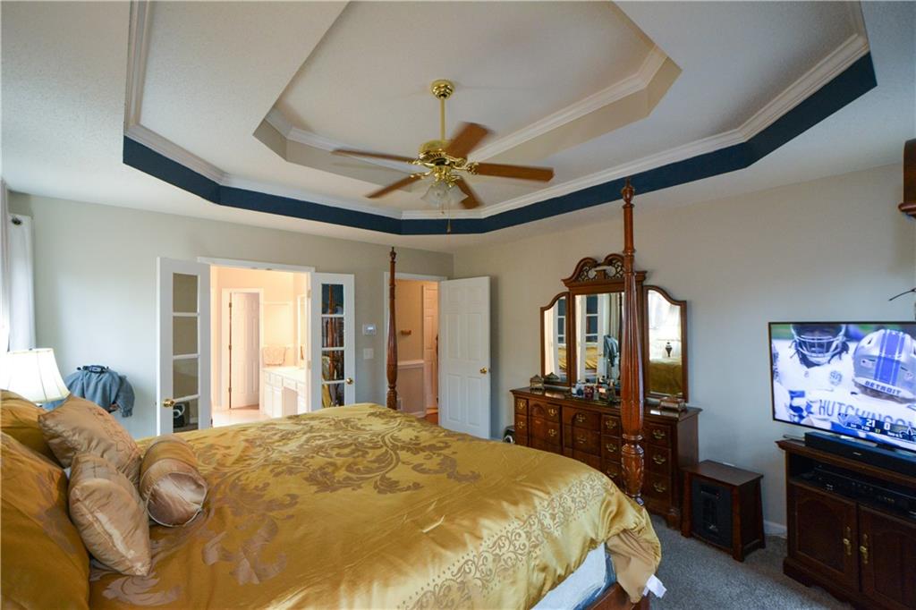 36 Austin Trail Douglasville, GA 30134 - Photo 20 of 43 a bedroom with a bed dresser and a chandelier