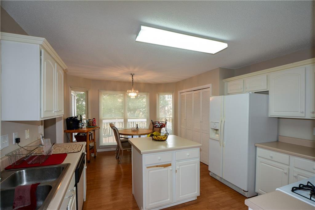 36 Austin Trail Douglasville, GA 30134 - Photo 10 of 43 a kitchen with a refrigerator a stove a sink dishwasher and white cabinets with wooden floor