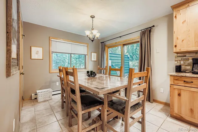 a dining room with furniture a chandelier and wooden floor