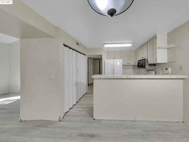 a kitchen with stainless steel appliances granite countertop a refrigerator a sink a stove a microwave and island