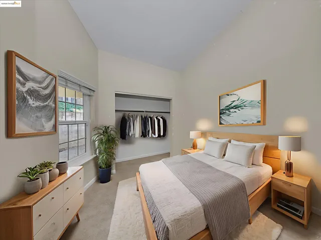 a bedroom with bed and paintings on the wall