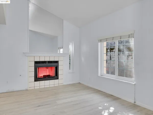 a view of an empty room with window and fire place