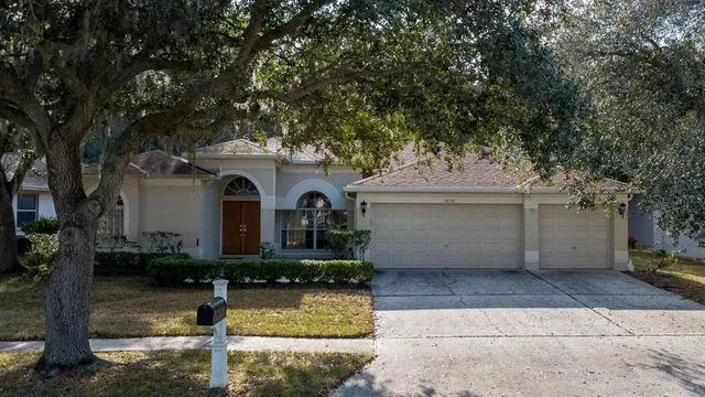 a front view of a house with a yard garage and outdoor seating