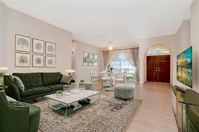 a living room with furniture a flat screen tv and a large window