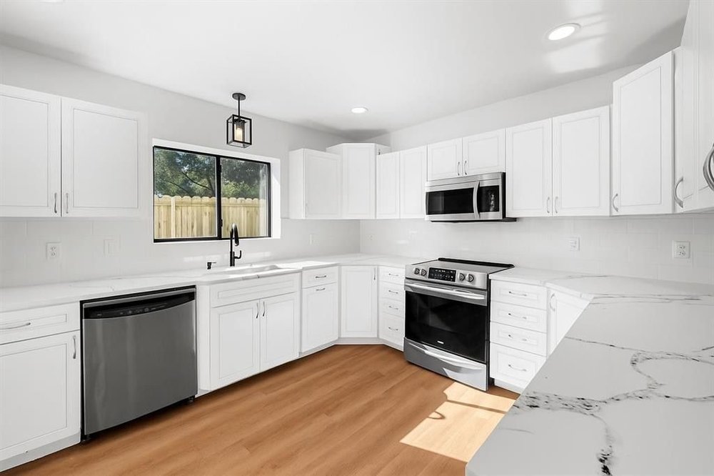 20204 Barnett Glenn Road Spicewood, TX 78669 - Photo 11 of 34 a kitchen with granite countertop white cabinets stainless steel appliances and sink