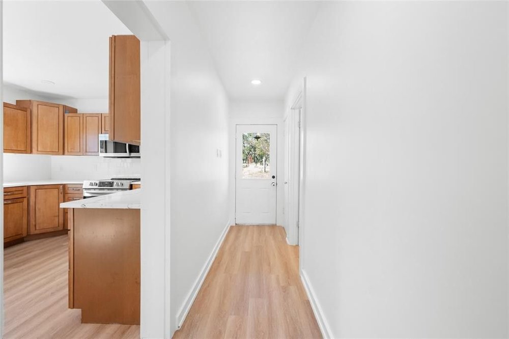 20204 Barnett Glenn Road Spicewood, TX 78669 - Photo 4 of 34 a view of a kitchen with a sink and a refrigerator