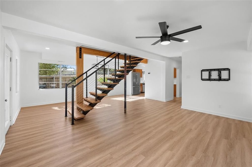 20204 Barnett Glenn Road Spicewood, TX 78669 - Photo 7 of 34 a view of an empty room with wooden floor and stairs
