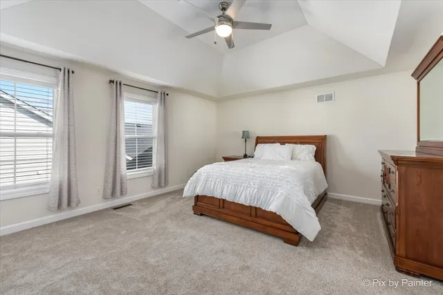 a spacious bedroom with a bed and a chandelier