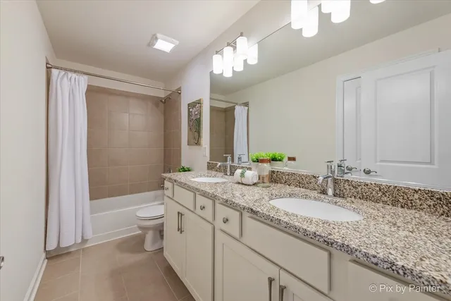 a bathroom with a granite countertop sink a toilet a mirror a bathtub and shower