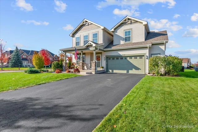 a front view of a house with a yard and potted plants