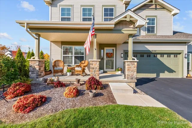a sign board with a house in the background