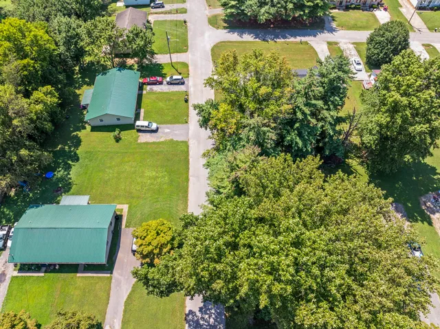 an aerial view of a house with swimming pool and garden