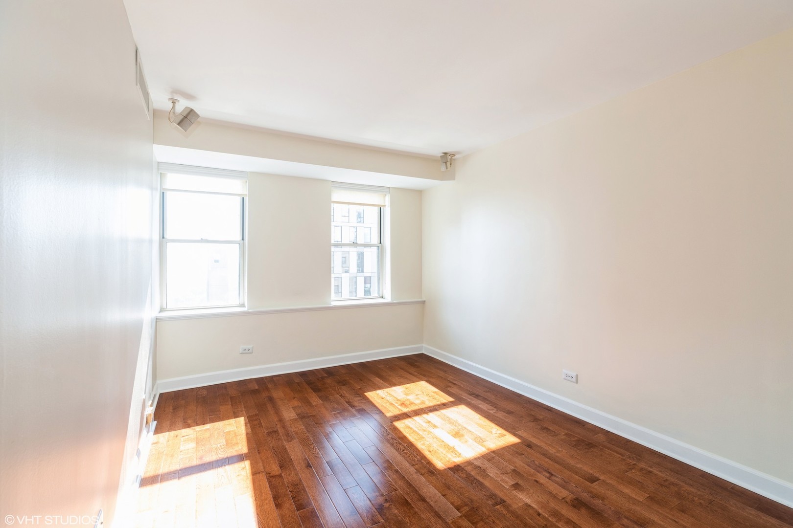 40 East 9th Street, Unit 1605 Chicago, IL 60605 - Photo 12 of 21 an empty room with wooden floor and windows