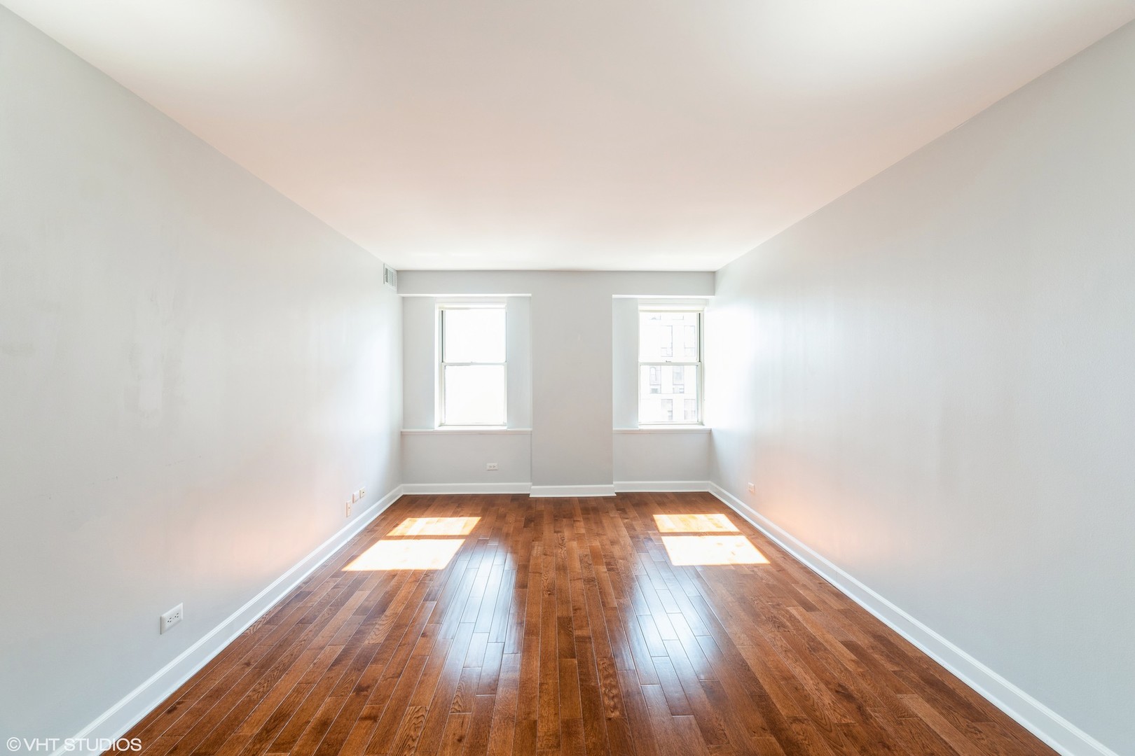 40 East 9th Street, Unit 1605 Chicago, IL 60605 - Photo 13 of 21 an empty room with wooden floor and windows