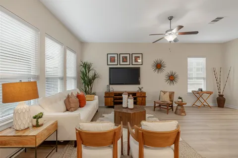 a living room with furniture a large window and a flat screen tv