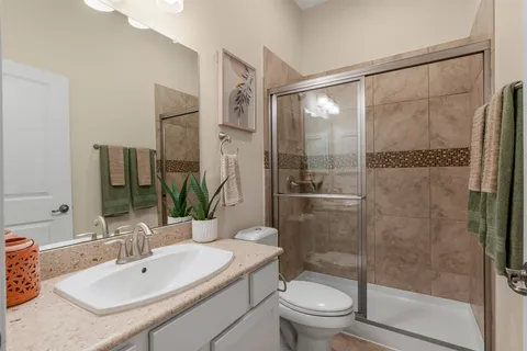 a bathroom with a sink mirror toilet and shower