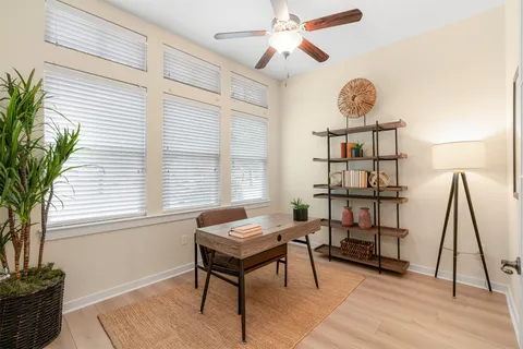 a view of a workspace with furniture and a window