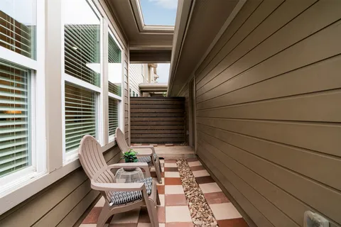 a balcony with chairs and wooden floor