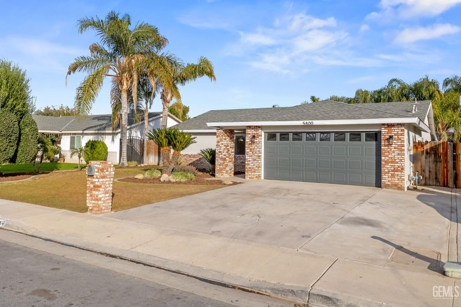 Undisclosed Address Bakersfield, CA 93304 - Photo 3 of 31 a front view of a house with a yard and palm trees