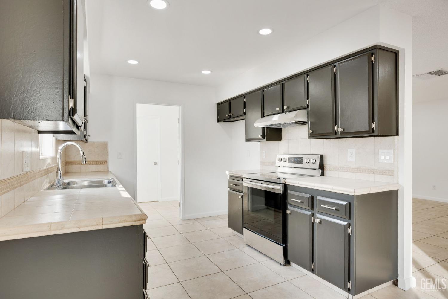 Undisclosed Address Bakersfield, CA 93304 - Photo 8 of 31 a kitchen with stainless steel appliances a sink a stove and a refrigerator