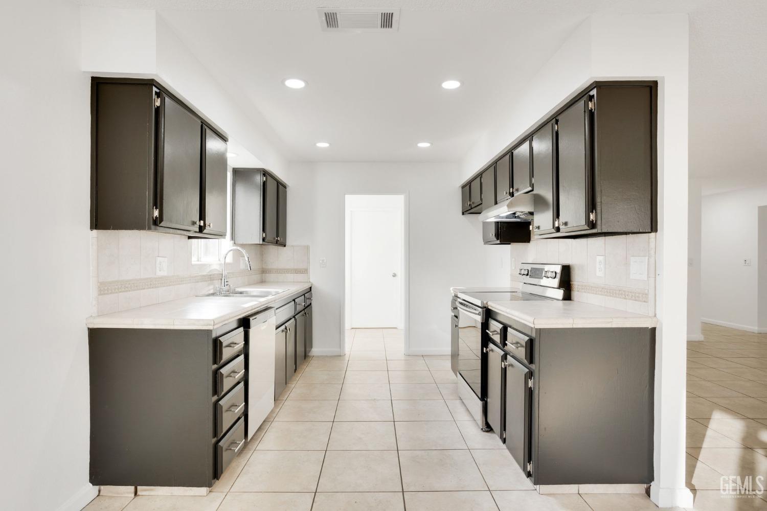 Undisclosed Address Bakersfield, CA 93304 - Photo 9 of 31 a kitchen with stainless steel appliances granite countertop a sink and a stove