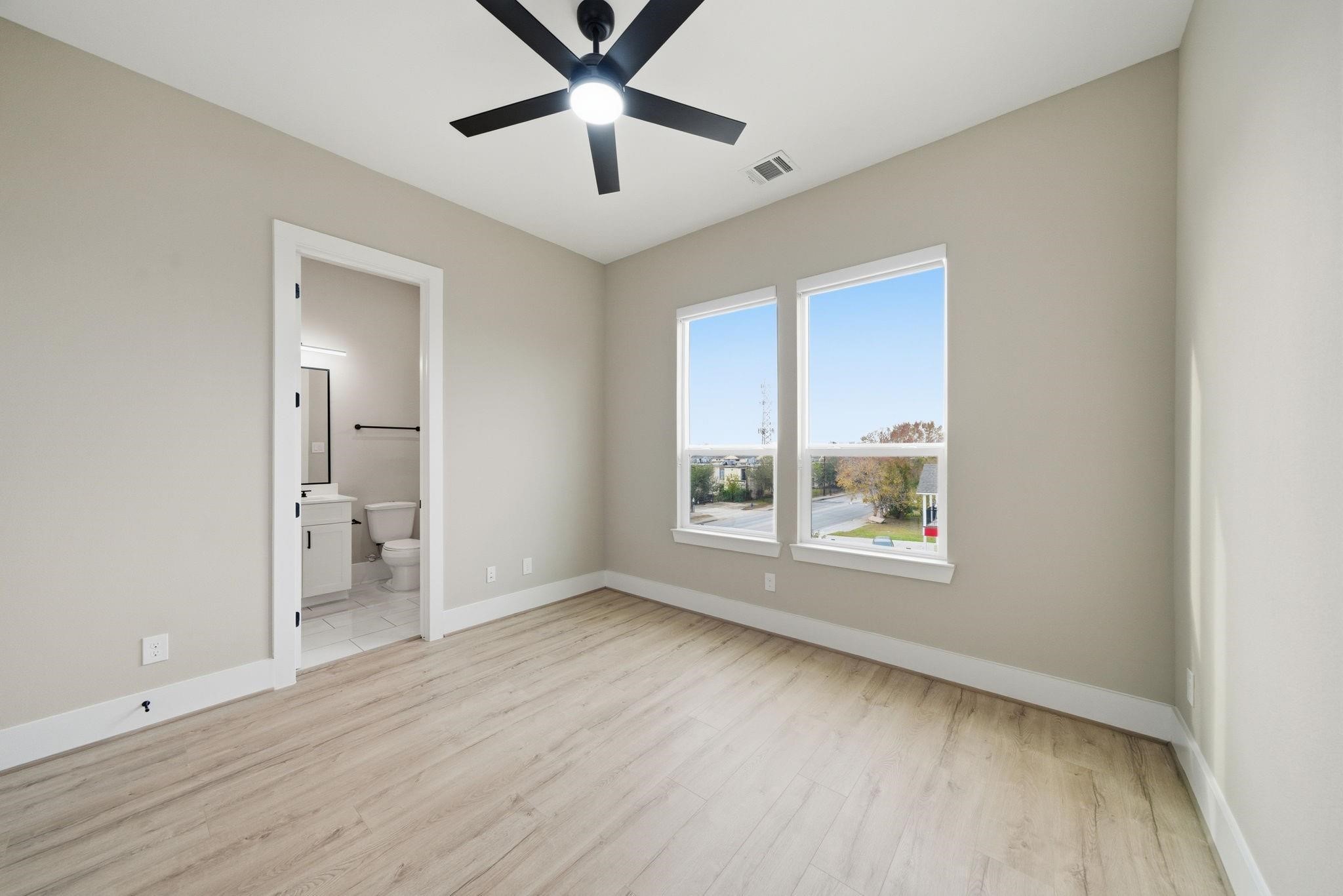 4013 Griggs Road, Unit F Houston, TX 77021 - Photo 18 of 35 Bright bedroom with large windows, light wood flooring, and an en-suite bathroom for added convenience.