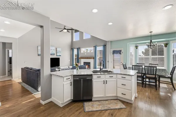 a kitchen that has a lot of cabinets in it and wooden floors