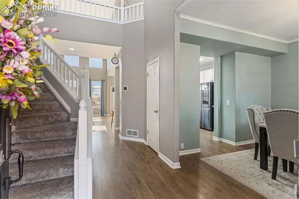 a view of a hallway with wooden floor and stairs