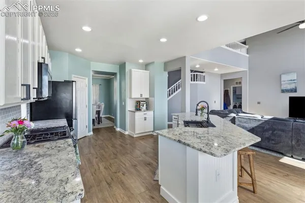 a kitchen with stainless steel appliances granite countertop a sink refrigerator and cabinets