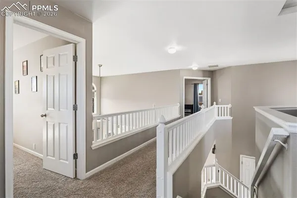 a view of a hallway with windows and stairs