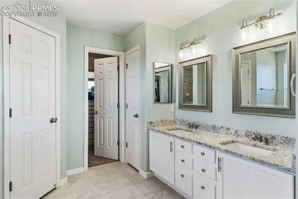 a bathroom with double sink and a mirror
