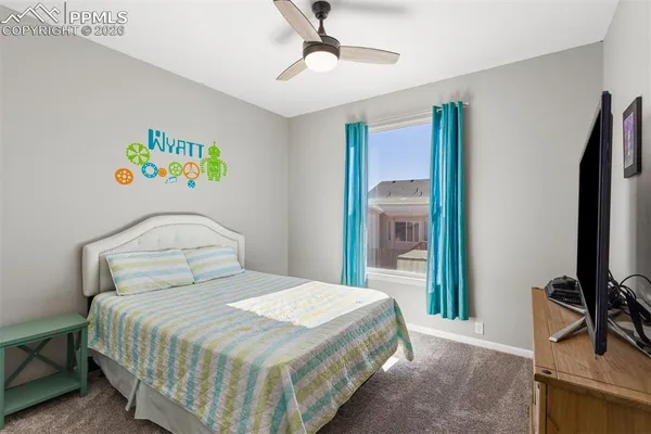a bedroom with a bed and a flat tv screen on the dresser