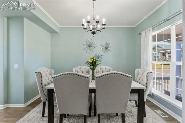 a view of a dining room with furniture wooden floor and chandelier