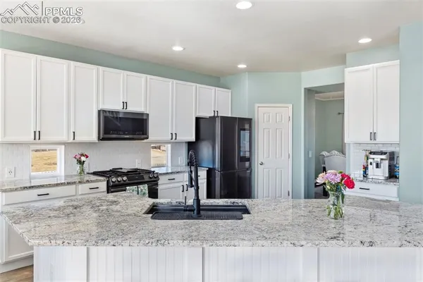 a kitchen with granite countertop a refrigerator sink and stove